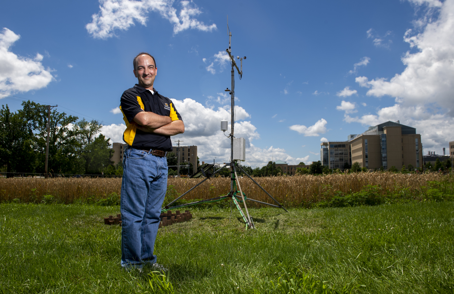 Eric Aldrich stands beside the Sanborn Field weather station on the MU campus.