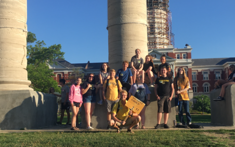 A student group poses in front of the Columns on the University of Missouri's campus.